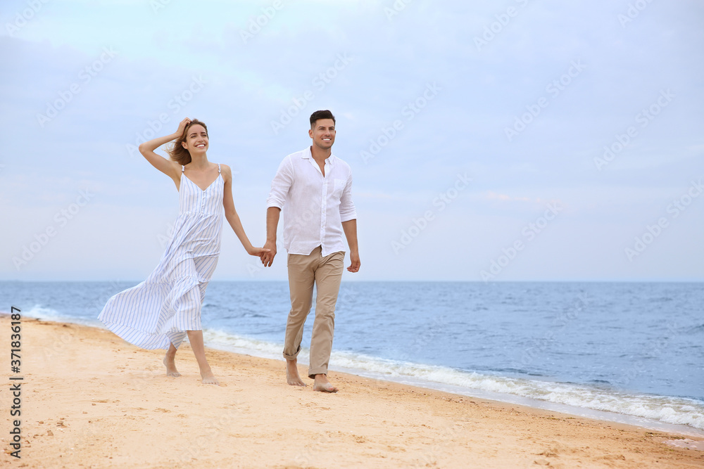 Happy couple having romantic walk on beach. Space for text Happy couple having romantic walk on beach. Space for text