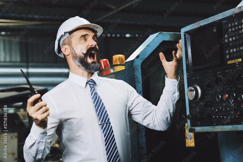 A man wearing hard hat feeling angry in factory, engineering man upset with his Colleague. A man wearing hard hat feeling angry in factory, engineering man upset with his Colleague.