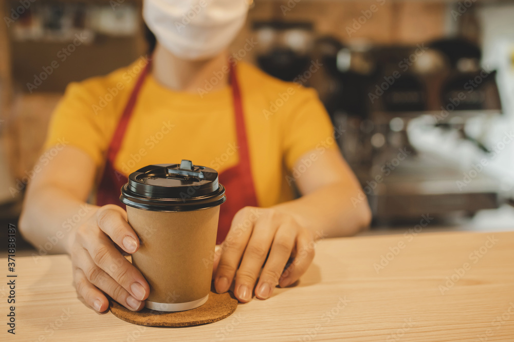 friendly woman barista or waitress wearing protection face mask waiting for serving hot coffee cup to customer in cafe coffee shop, cafe restaurant, service mind, new normal, food and drink concept