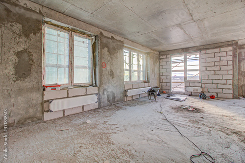 Unfinished construction empty room. Walls from lightweight aggregate concrete blocks with empty doorframes, unfinished interior, house under construction