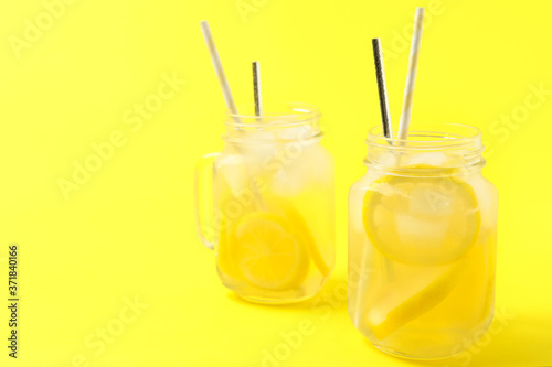 Natural lemonade on yellow background, space for text. Summer refreshing drink