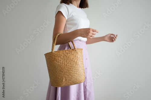 eco bag: a woman in a stylish skirt holds a straw basket