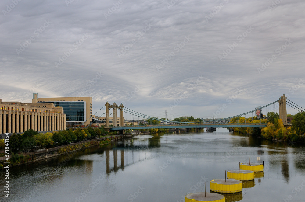 Obraz premium Hennepin Avenue suspension brdige over the Mississippi river at Minneapolis with Post Office and Federal Reserve Bank
