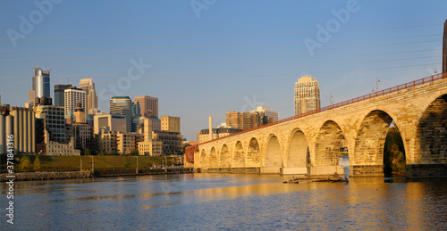 Minneapolis highrise tower skyline and the Stone Arch Bridge on the Mississippi at sunrise