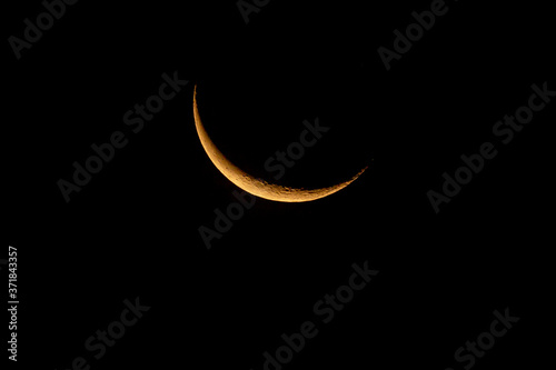 Waning crescent moon rising in the early dawn.