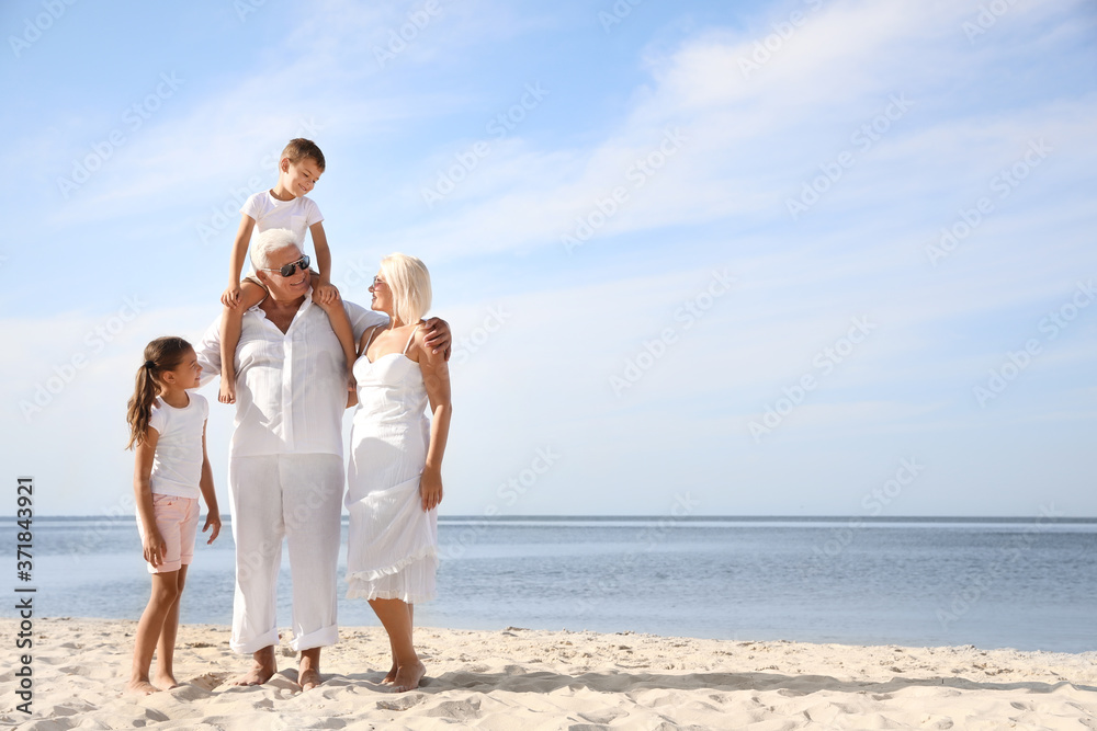 Cute little children with grandparents spending time together on sea beach Cute little children with grandparents spending time together on sea beach