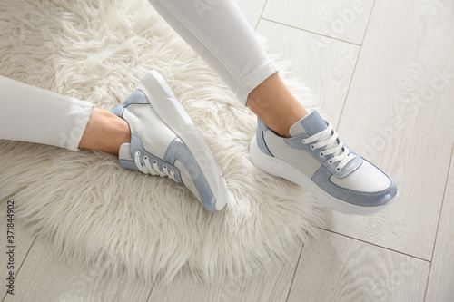 Woman wearing comfortable stylish sneakers indoors, closeup