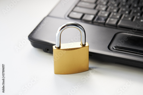 golden padlock on a black laptop keyboard over white background. internet security concept. antivirus software concept. electronic wallet symbol