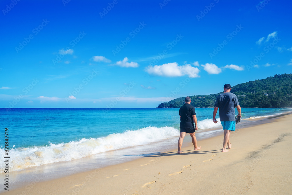 People walking relax on the sand beach in blue sky and morning light