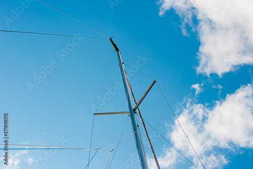 yacht mast against the background of blue sky and clouds