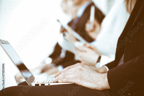 Business people working at meeting or conference  close-up of hands. Group of unknown businessmen and women in modern white office. Teamwork or coaching concept
