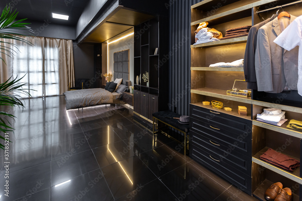Fototapeta premium dark modern stylish male apartment interior with lighting, decorative walls, fireplace, dressing area and huge window