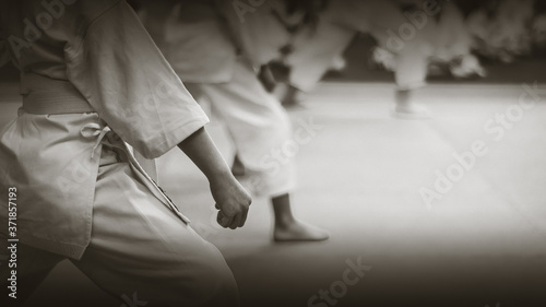 Kids training on karate-do. Black and white. Photo without faces. Imitation of film photography.