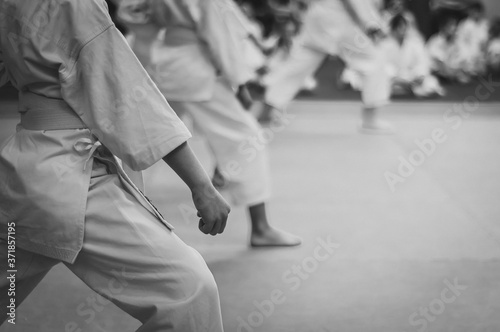 Kids training on karate-do.  Black and white. Photo without faces.Simulating the grain of film photography.