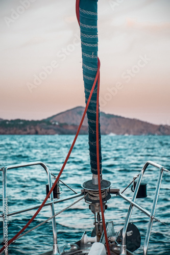 Mast of a sailing boat at open sea in sunset