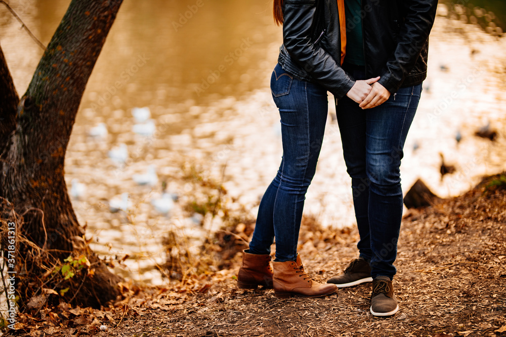 legs. man and woman hug in autumn Park near river. legs. man and woman hug in autumn Park near river.