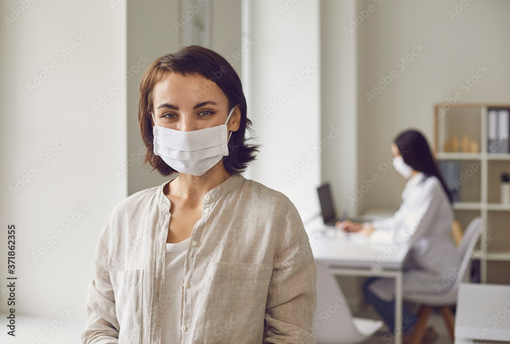Woman wearing medical mask on visit to doctor at clinic. Patient at hospital after consultation