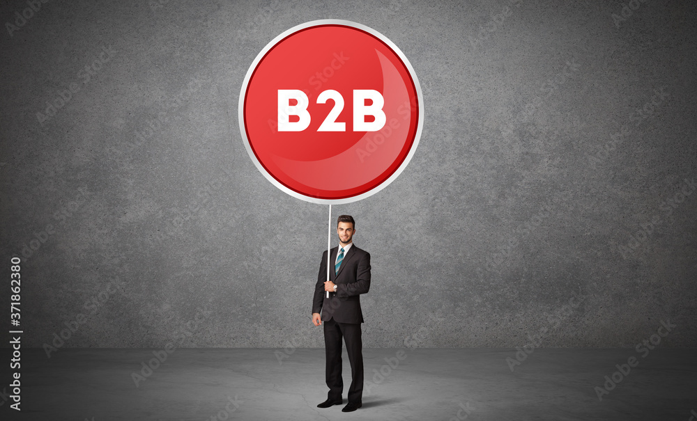 Young business person holdig traffic sign with B2B abbreviation, technology solution concept Young business person holdig traffic sign with B2B abbreviation, technology solution concept