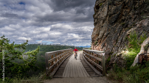 Biking over the Wooden Trestle Bridges of the abandoned Kettle Valley Railway in Myra Canyon near Kelowna, British Columbia, Canada photo