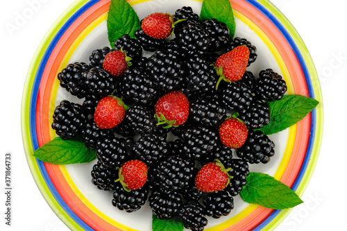 Strawberry  blackberry and fresh mint leaves on the plate. Fresh organic fruit. Colorful healthy fruits.