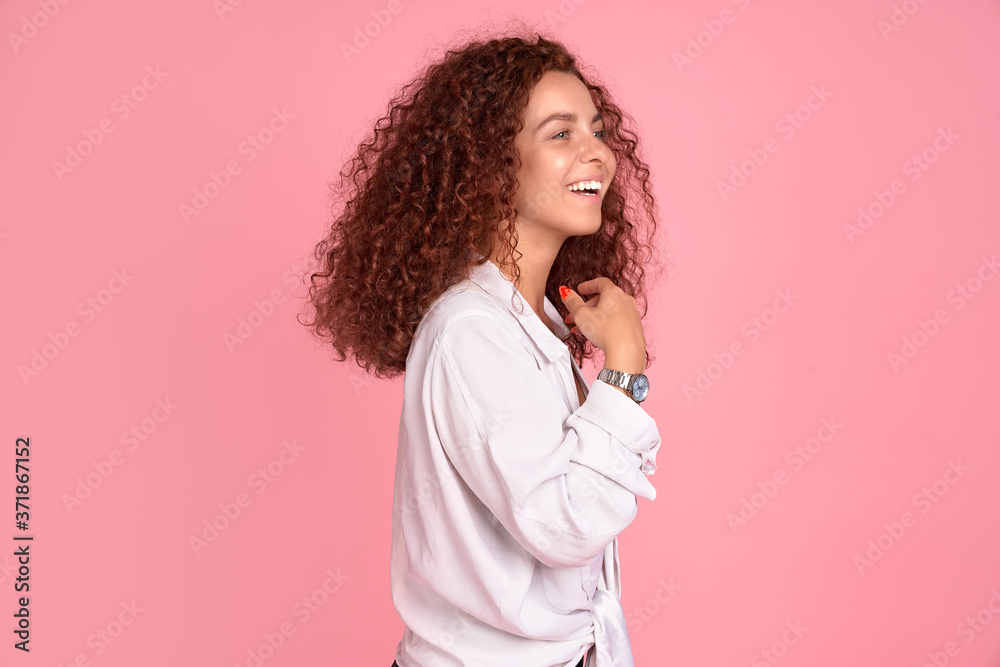 Cheerful foxy beautiful girl smiling laughing rejoicing looking side over pink background. Cheerful foxy beautiful girl smiling laughing rejoicing looking side over pink background.