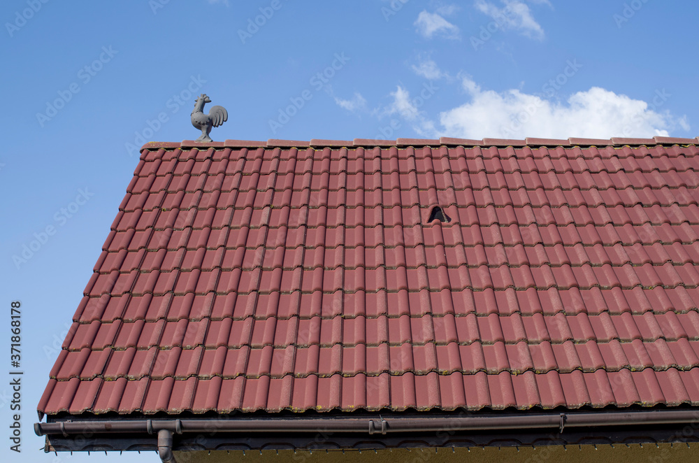 New tiled roof with louvered roof vent and cock in the sky New tiled roof with louvered roof vent and cock in the sky