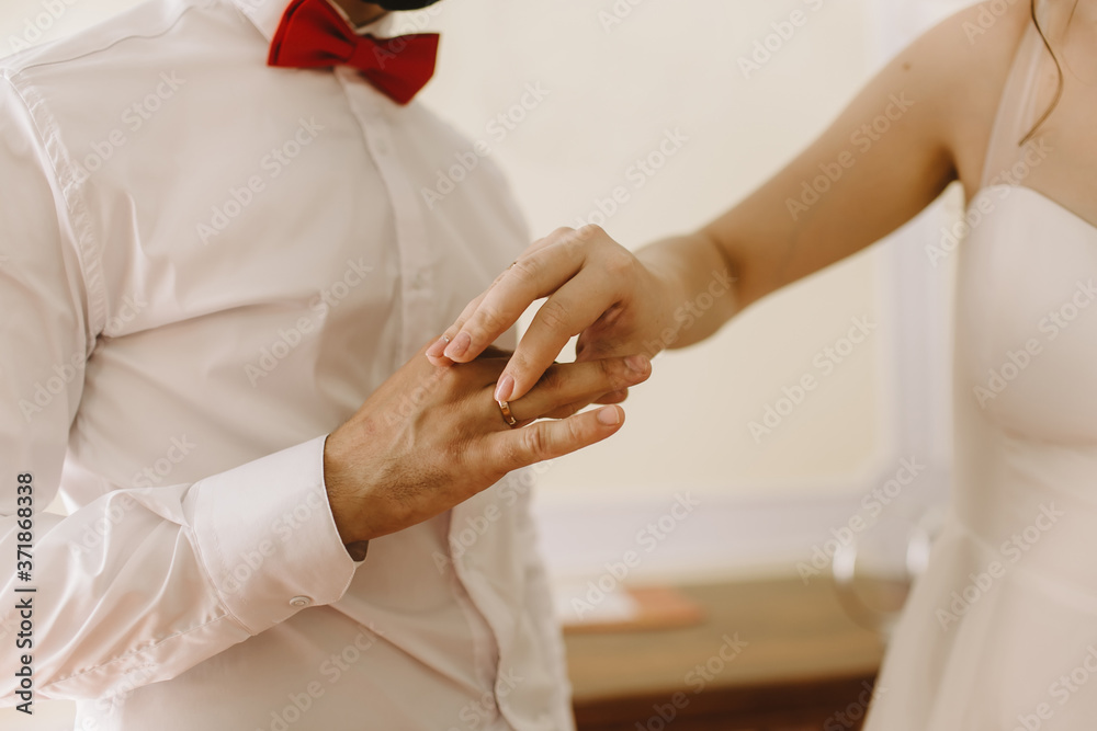 The bride wears a wedding ring on groom on right hand ring finger on her wedding day.