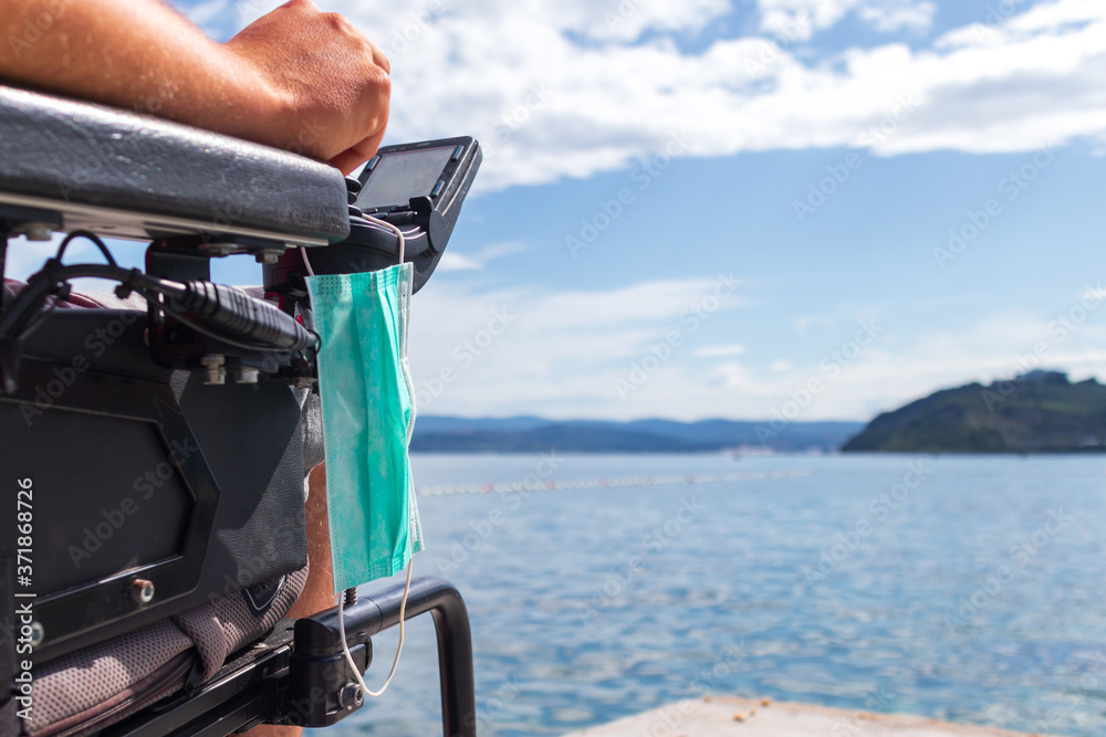 Fototapeta premium Coronavirus face mask on wheelchair to be used for protection and hygiene.