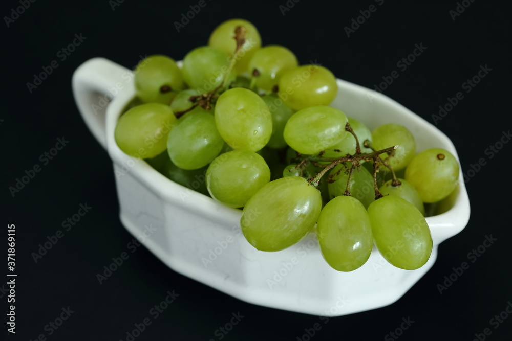  Fresh juicy  grapes on in a bowl close up on black background