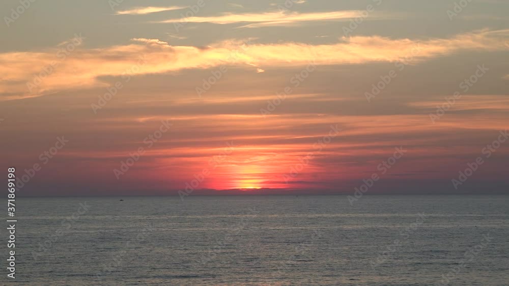 glowing sunset over calm lake waters sun hiding behind pastel pink orange clouds, boat in water static Lake Huron Ontario glowing sunset over calm lake waters sun hiding behind pastel pink orange clouds, boat in water static Lake Huron Ontario