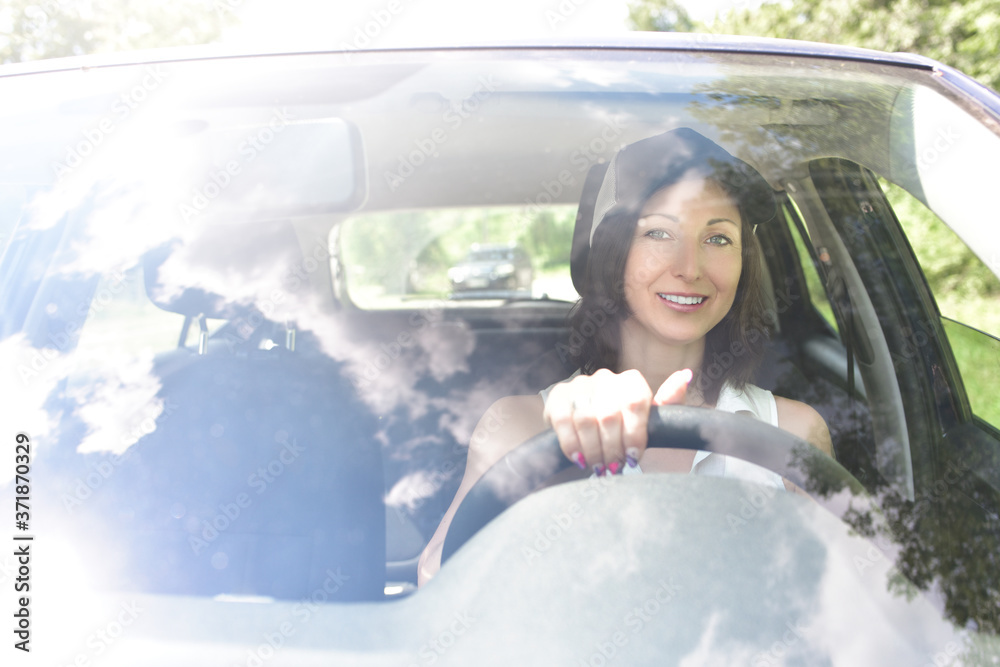 Φωτογραφία Beautiful adult happy woman wearing hat driving her car in summer day