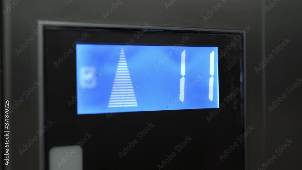 Led blue screen of grey elevator rising up. Handheld shot of lcd screen monitor showing numbers in elevator, showing from ninth to fifteenth floor Led blue screen of grey elevator rising up. Handheld shot of lcd screen monitor showing numbers in elevator, showing from ninth to fifteenth floor