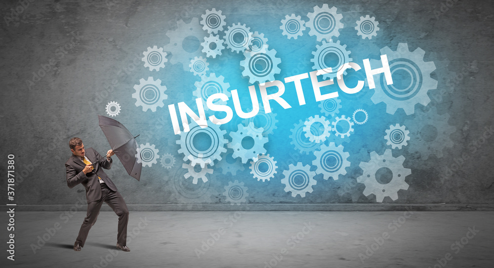 Businessman defending with umbrella from INSURTECH inscription, technology concept Businessman defending with umbrella from INSURTECH inscription, technology concept