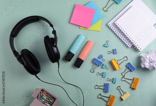 earphones and stationary items on mint background