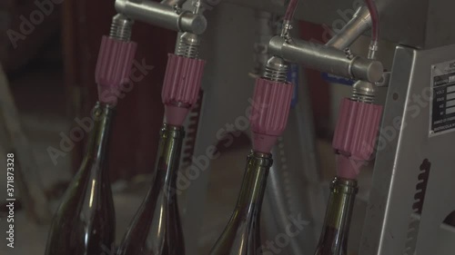 Close up on a vintage wine bottle filling process, small traditional winery