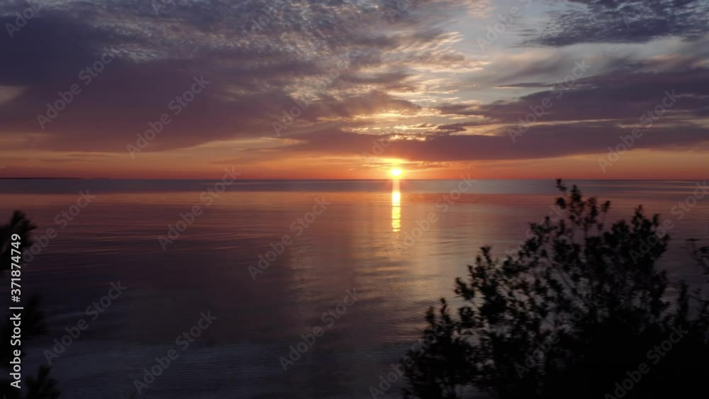 Red sunset over great lakes with treetops in foreground, Aerial Dolly Drone Shot Red sunset over great lakes with treetops in foreground, Aerial Dolly Drone Shot