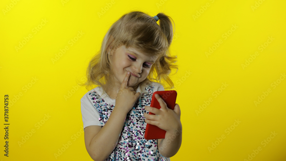 Child girl scrolling social network posts on smartphone. Remote online shopping, browsing on phone.