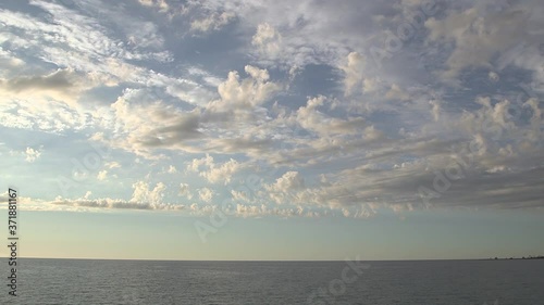 Sunset skyline with altocumulous clouds moving wide static glowing gold yellow painting island Lake Huron daytime Ontario  photo