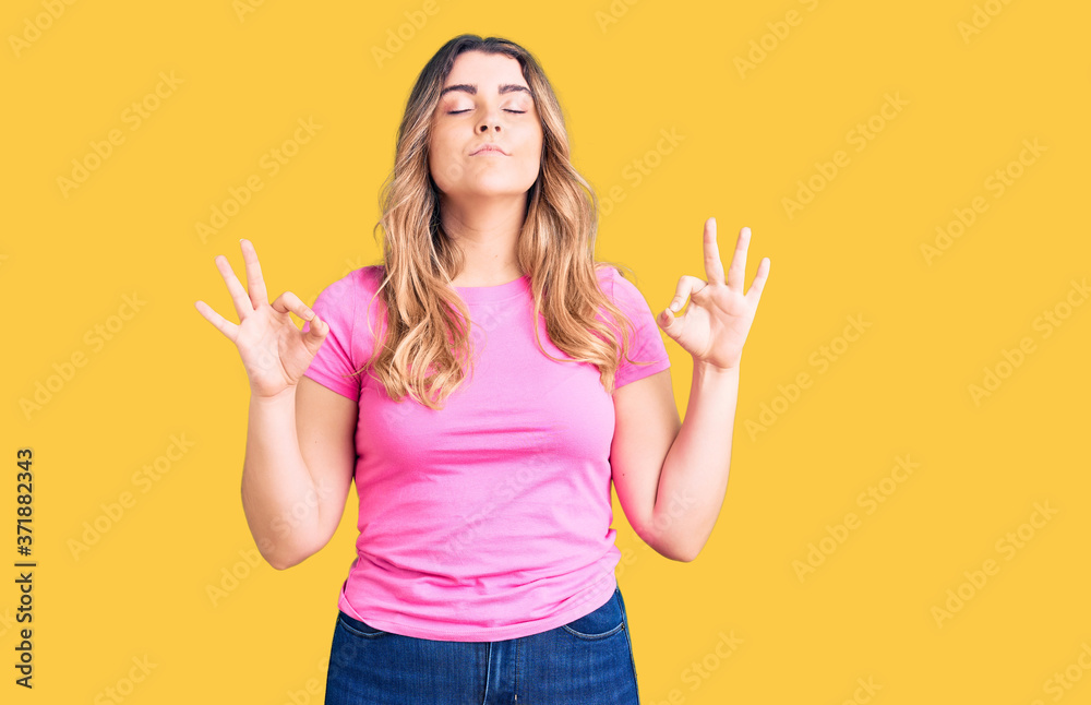 Young caucasian woman wearing sportswear relax and smiling with eyes closed doing meditation gesture with fingers. yoga concept. Young caucasian woman wearing sportswear relax and smiling with eyes closed doing meditation gesture with fingers. yoga concept.