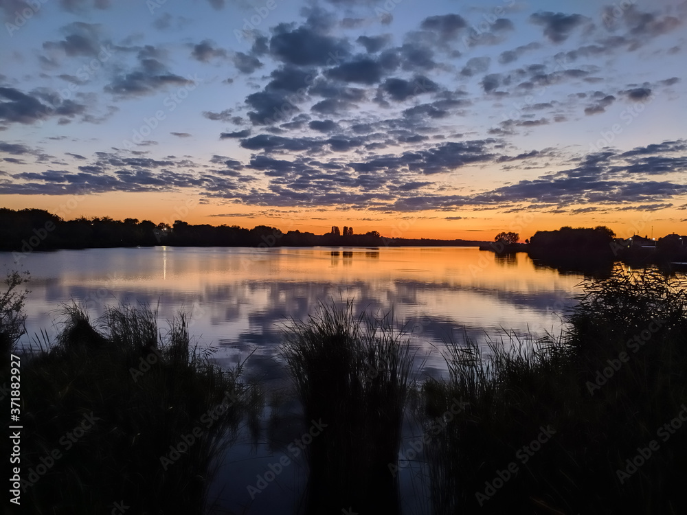 Sunbeams at sunset are reflected in the lake