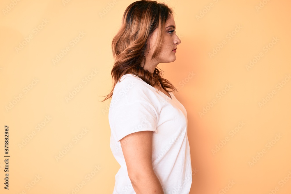 Young beautiful caucasian woman wearing casual white tshirt looking to side, relax profile pose with natural face with confident smile. Young beautiful caucasian woman wearing casual white tshirt looking to side, relax profile pose with natural face with confident smile.