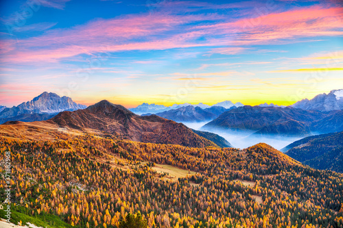 Autumn landscape with yellow larches and awesome Monte Civetta at sunset seen from Falzarego pass.