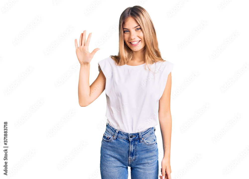 Beautiful caucasian woman with blonde hair wearing casual white tshirt showing and pointing up with fingers number five while smiling confident and happy. Beautiful caucasian woman with blonde hair wearing casual white tshirt showing and pointing up with fingers number five while smiling confident and happy.