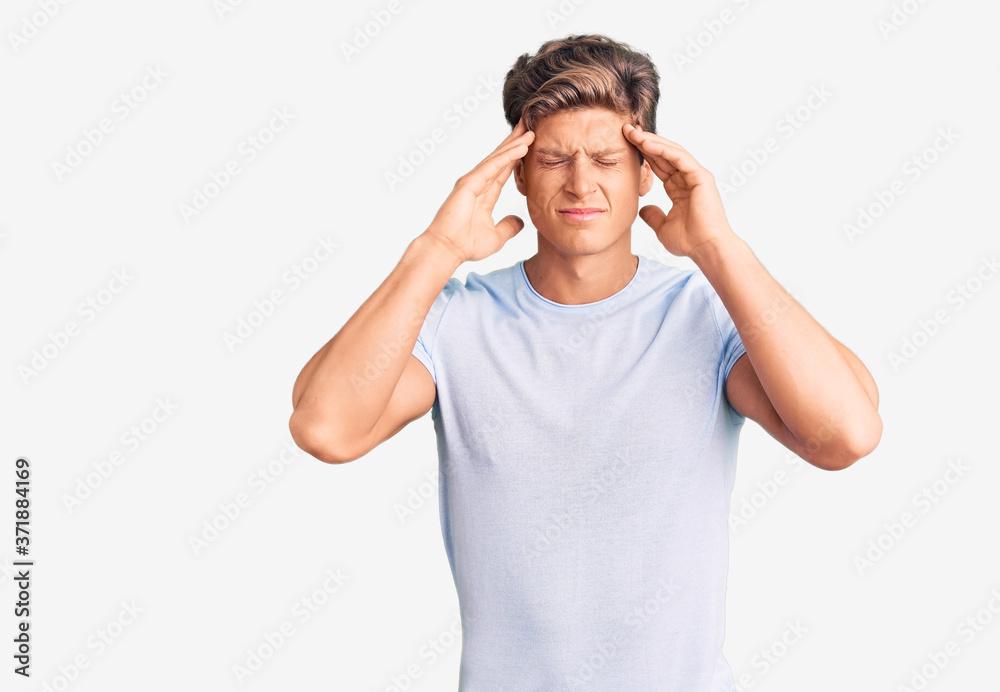 Young handsome man wearing casual clothes suffering from headache desperate and stressed because pain and migraine. hands on head. Young handsome man wearing casual clothes suffering from headache desperate and stressed because pain and migraine. hands on head.