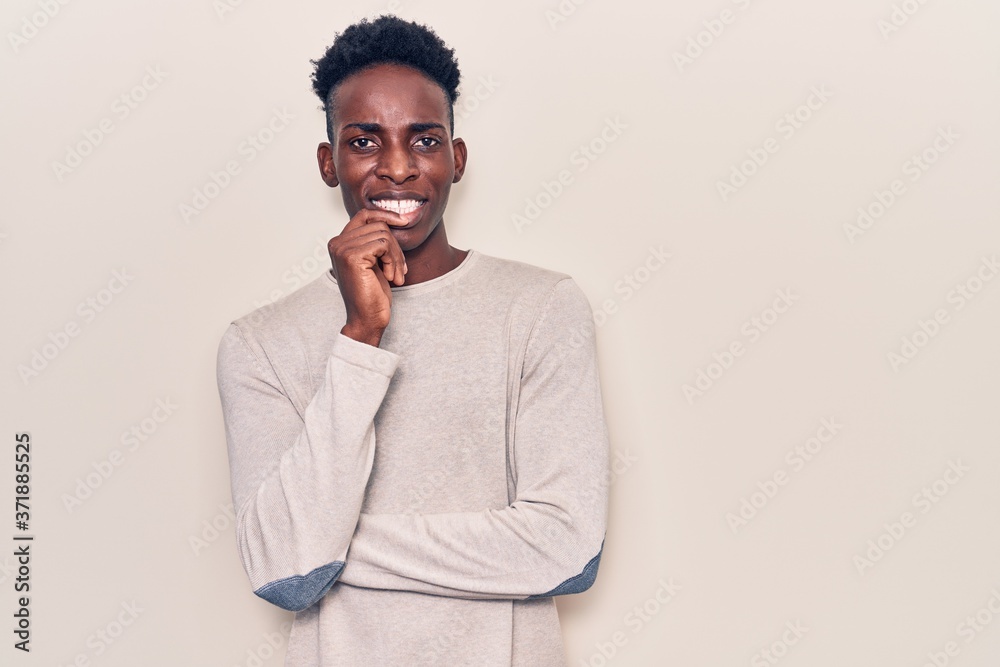 Young african american man wearing casual clothes smiling looking confident at the camera with crossed arms and hand on chin. thinking positive. Young african american man wearing casual clothes smiling looking confident at the camera with crossed arms and hand on chin. thinking positive.