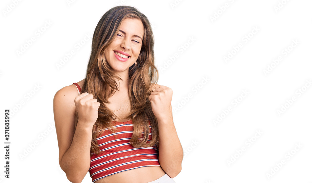 Beautiful caucasian young woman wearing casual clothes excited for success with arms raised and eyes closed celebrating victory smiling. winner concept. Beautiful caucasian young woman wearing casual clothes excited for success with arms raised and eyes closed celebrating victory smiling. winner concept.
