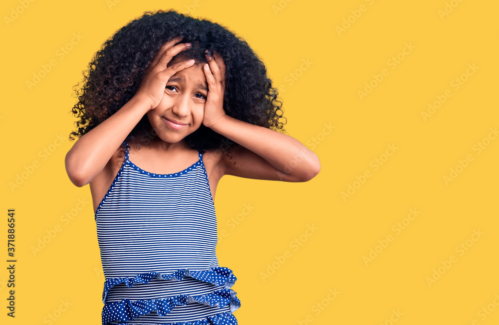 African american child with curly hair wearing swimwear suffering from headache desperate and stressed because pain and migraine. hands on head. African american child with curly hair wearing swimwear suffering from headache desperate and stressed because pain and migraine. hands on head.