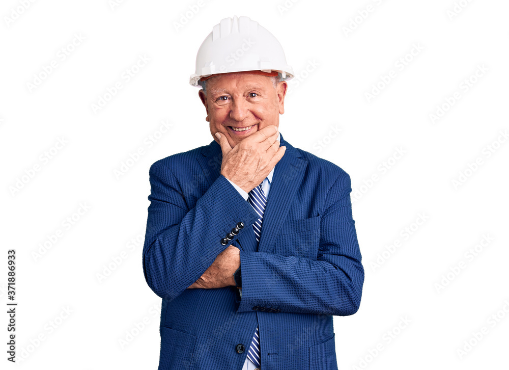 Senior handsome grey-haired man wearing suit and architect hardhat looking confident at the camera smiling with crossed arms and hand raised on chin. thinking positive.