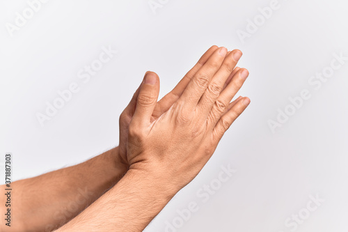 Hand of caucasian young man showing fingers over isolated white background touching palms praying with both hands together  catholic religious symbol