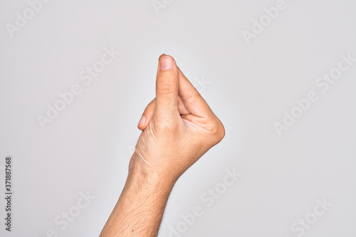 Hand of caucasian young man showing fingers over isolated white background holding blank space with thumb finger, business and advertising